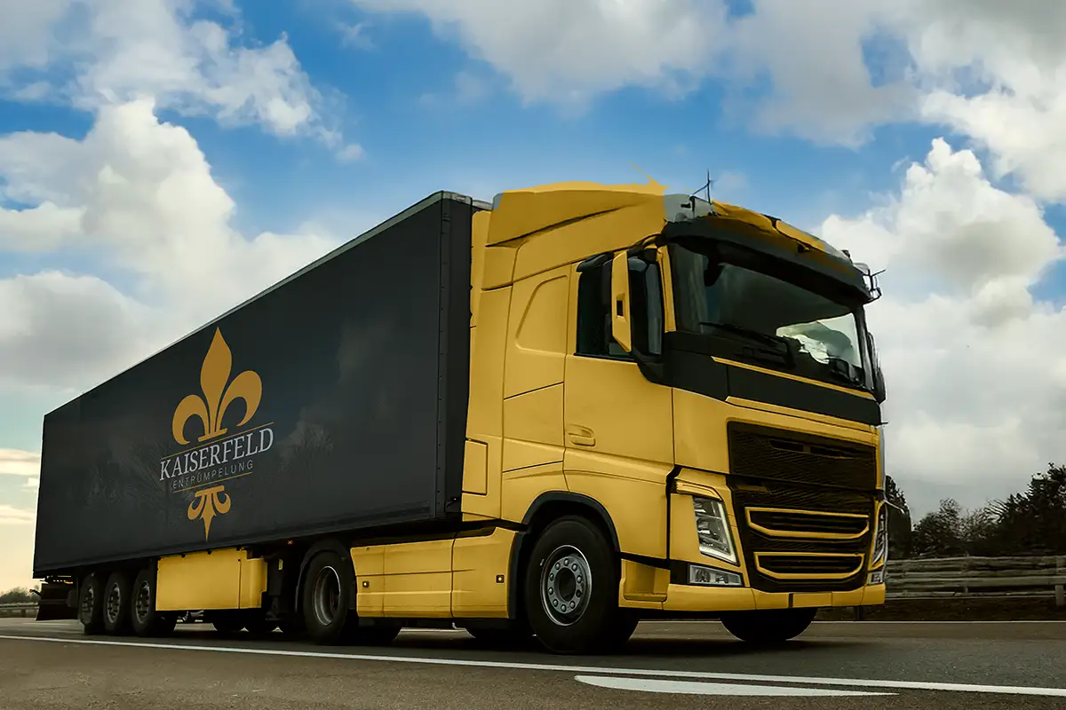 Kaiserfeld Entrümpelung Ein Lkw mit dem Logo von Kaiserfeld Entrümpelung fährt auf einer Straße