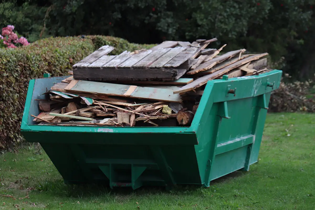 Kaiserfeld Entrümpelung Ein Container voller Bauschutt steht auf einer Wiese